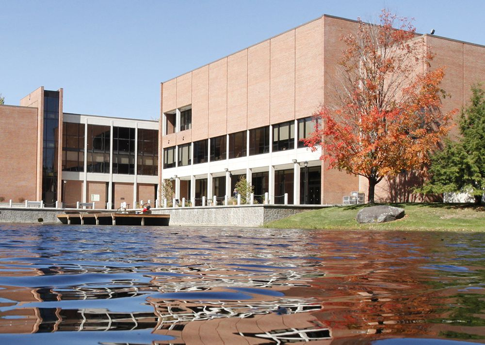 SUNY Oneonta campus building with outdoor tables in front.